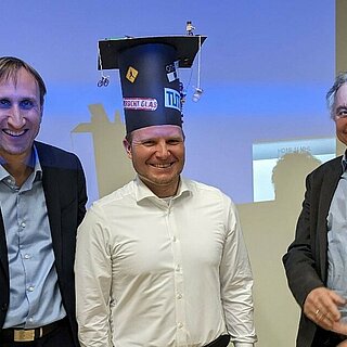 Prof. Michael Sterner, Dr. Sebastian Gärtner und Prof. Matthias Gaderer bei der Übergabe des Doktorhutes.